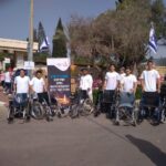 מתנדבים מסייעים עם כסאות גלגלים ביום הזכרון כדי להקל על ההגעה לקבר